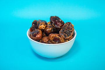 A small bowl of dates is served as a menu for breaking the fast with a Tosca background for the blessed month of Ramadan