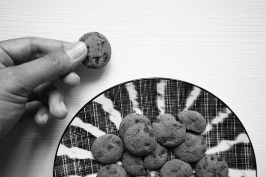 Grayscale Of A Hand Holding A Cookie