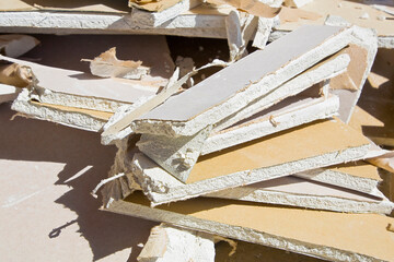 Demolished plasterboard wall, made of plaster and cardboard, wit