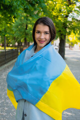 Smiling girl with Ukrainian flag. War in Ukraine