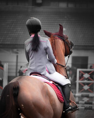 Equestrian woman showjumping during the daytime