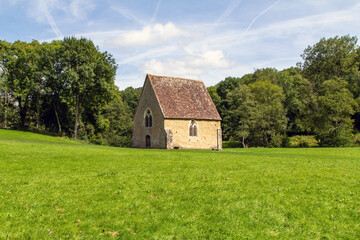 Fototapeta na wymiar Capilla de Saint-Céneri-le-Gérei. La capilla está ubicada en una enorme pradera a las afueras del pueblo. Baja Normandía, Francia.