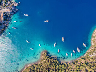 Aerial drone footage of daily tour boats and private yachts anchored in Cennet Bay, located in Selimiye village of Marmaris District of Muğla City, Turkey. © gokcen