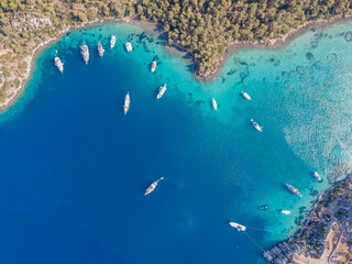 Aerial drone footage of daily tour boats and private yachts anchored in Cennet Bay, located in...
