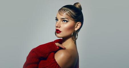Portrait of a beautiful young tanned woman with a smooth hairstyle and bright red lips. The model...
