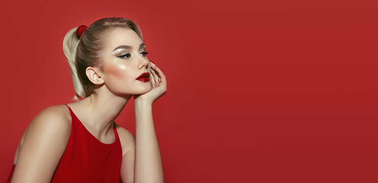 Portrait of a beautiful young blonde woman in a red dress with red lips.Retro style. Advertising cosmetics for the face.