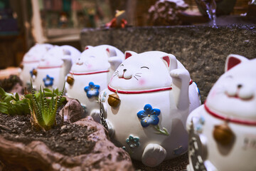 Selective focus shot of a Japanese Maneki Neko (a lucky cat) ceramic figurine with a smile