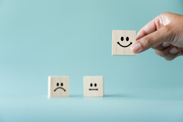Concept of customer satisfaction review. Wooden blocks with facial expression and the 