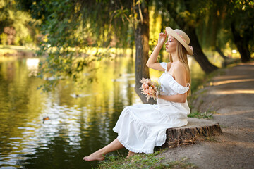 Fototapeta na wymiar Perfect blond girl in a white dress on nature