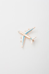 Metallic brooch in shape of airplane, pin on white background, bijouterie, jewelry close up