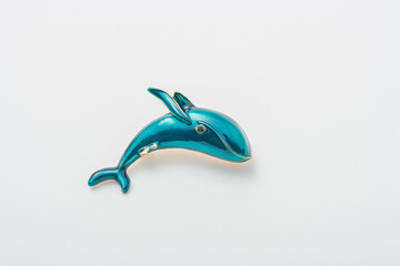 Metallic brooch in shape of blue whale, pin broach on white background, bijouterie, jewelry close up