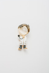 Metallic golden brooch in shape of male doctor with stethoscope, pin broach on white background. Bijouterie, jewelry for medical worker