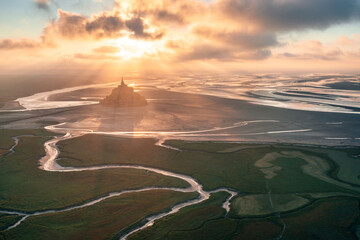 Aerial distant view of the Mont Saint-Michel during sunset in Normandy, France - obrazy, fototapety, plakaty