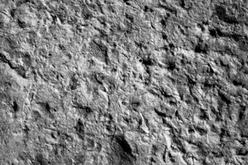 evocative black and white image of very porous wall plaster texture 

