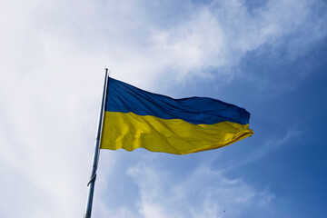 Flag of Ukraine flutters in blue sky. Large yellow blue Ukrainian national state flag. War Russia attacked Ukraine