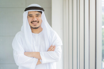 close up front view portrait of arabian businessman smile and arm crossed in office room for...