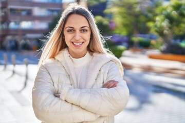 Young woman smiling confident standing with arms crossed gesture at street