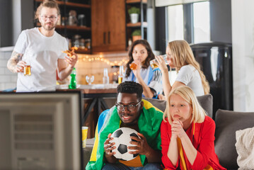Obraz premium Multicultural friends gathered together to watch the soccer football championship
