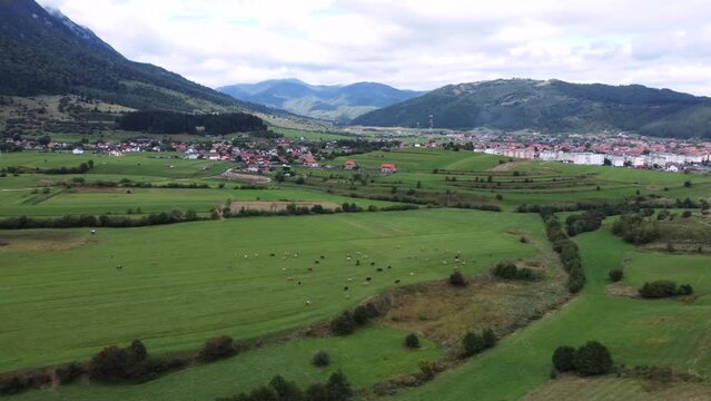 Drone footage of a rural village in the background in Zarnesti, Romania