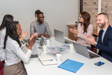 Group of smiling multi-ethnic business workers. Working together applauding the team leader in the office