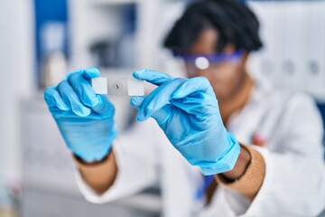 African american man scientist holding sample at laboratory