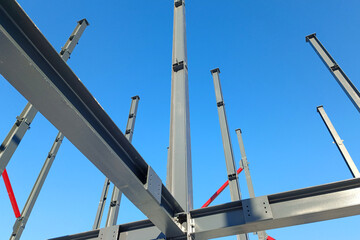 Iron beams against the blue sky. Construction of a large building