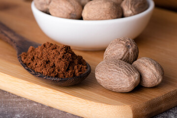 Nutmeg macro in a bowl. Nutmeg powder. Nutmeg spice in a wooden spoon.