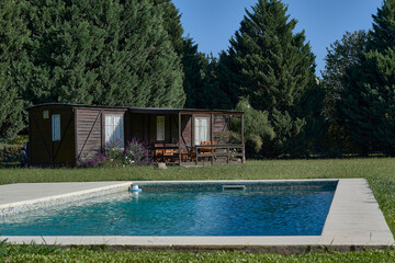 Remodeled train carriage for country house with the swimming pool in the forest in summer