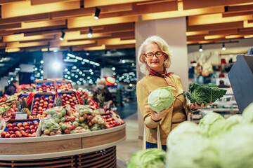 Woman in supermarket buying vegetables