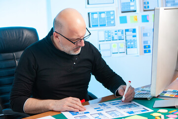Mobile app design. Web designer, UX UI designer, mobile phone app planning. The man develops the...