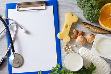 Bone shaped cheese, notebook, stethoscope and bone strengthening foods products, concept osteoporosis and prevention
