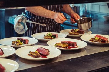 The hands of the chef preparing a fine dinner in the kitchen of a restaurant in London, England