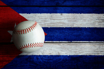 Leather Baseball on Rustic Wooden Background Painted With Cuban Flag. Cuba is one of the world's top baseball nations.