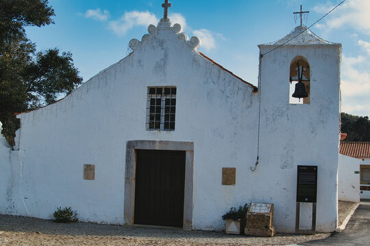 The 18th-century village church of Bordeira, Algarve, Portugal, with whitewashed walls and a small clocktower
