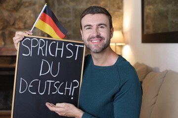 German teacher holding blackboard and flag. TRANSLATION OF THE TEXT IN THE IMAGE: 