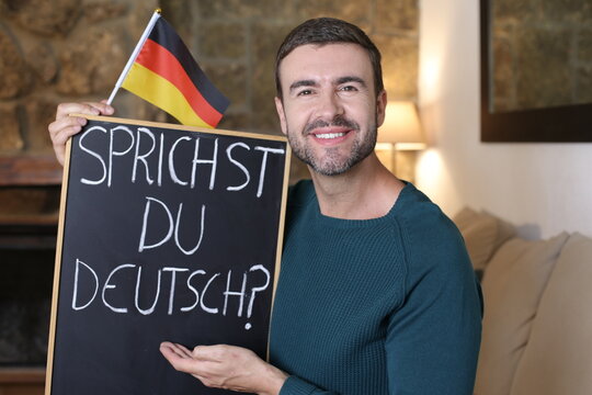 German teacher holding blackboard and flag