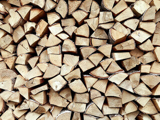 Woodpile folded  on one another in countryside, horizontal, background wooden wall texture. Preparation for winter, natural fuel, green energy, dry wood for fireplace, timber and logs, close up