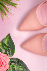 Pink style. Gently pink stylish shoes, decor of flowers on a pink background.