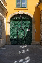 Green gates with an inscription in the Hungarian language that car parking is prohibited