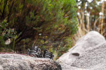 brown hiking boots on a gray stone with a green background