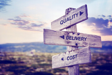 quality delivery cost text quote caption on wooden signpost outdoors in nature. Stock sign words...