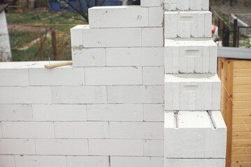 Laying autoclaved aerated concrete blocks with reinforcement and adhesive. Installing white blocks...