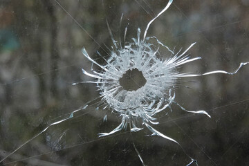 Shot through the window of a civilian house. Bullet hole in glass.