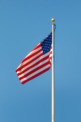 The American flag against a blue sky background