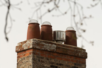 Bird protected chimney pots on red brick stack
