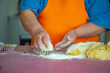 grandmother kneads the dough for Easter cakes. High quality photo