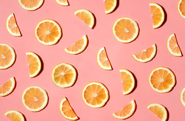 Pattern of many sliced lemons and oranges on a trendy bright pink background. Flat lay, top view. Summer freshness, detox, antioxidants, healthy lifestyle concept