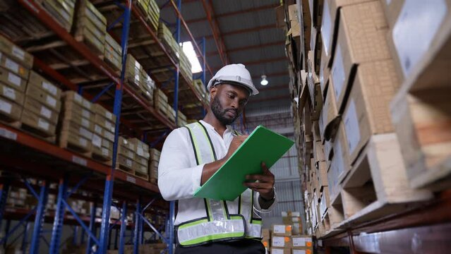 Business concept of 4k Resolution. African man checking goods in warehouse.