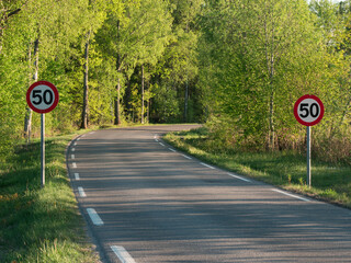 A country road meandering through Vestfold in Southern Norway with speed limit signs on either side.