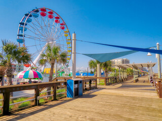 Een groot, kleurrijk reuzenrad aan de Carolina Beach-promenade in Noord-Carolina onder een blauwe hemel.